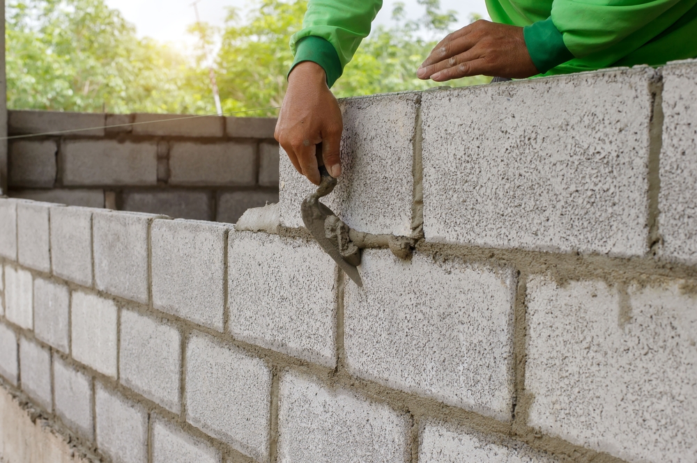 Masonry,worker,make,concrete,wall,by,cement,block,and,plaster